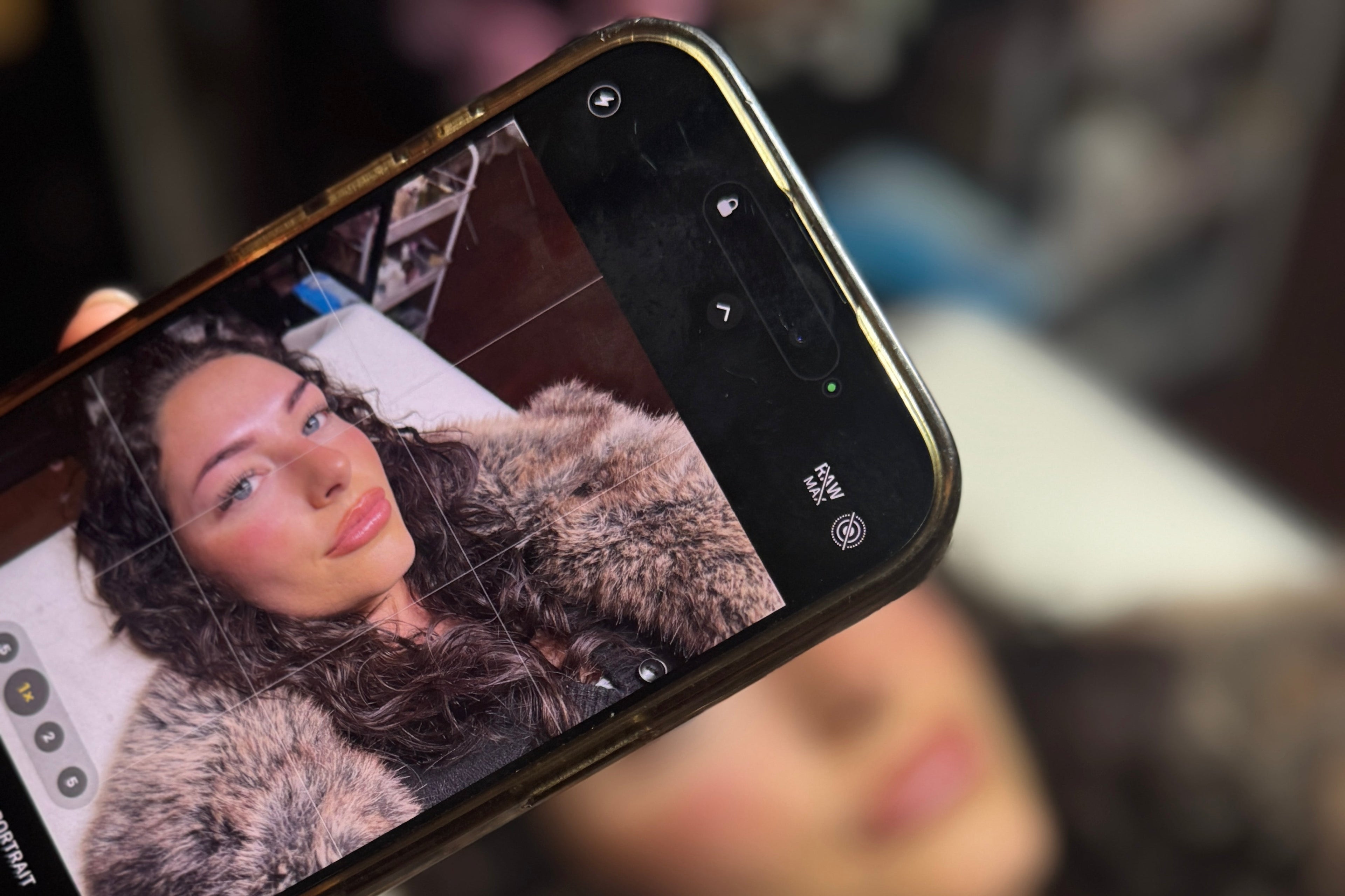Smartphone displaying a photo of a woman with her lashes and brows done